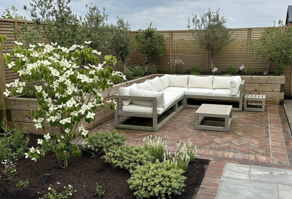 Landscaped garden showcasing a comfortable sofa and decorative plants.